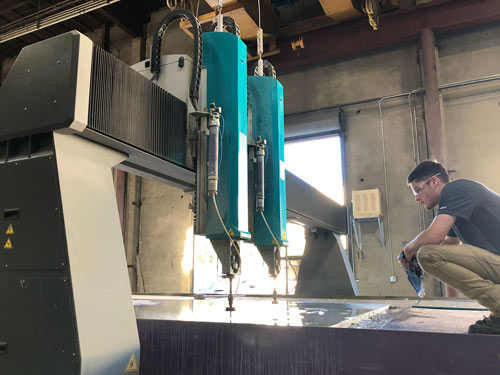 man watching waterjet cutting